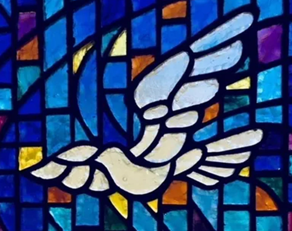 A stained glass window depicting the dove of peace.