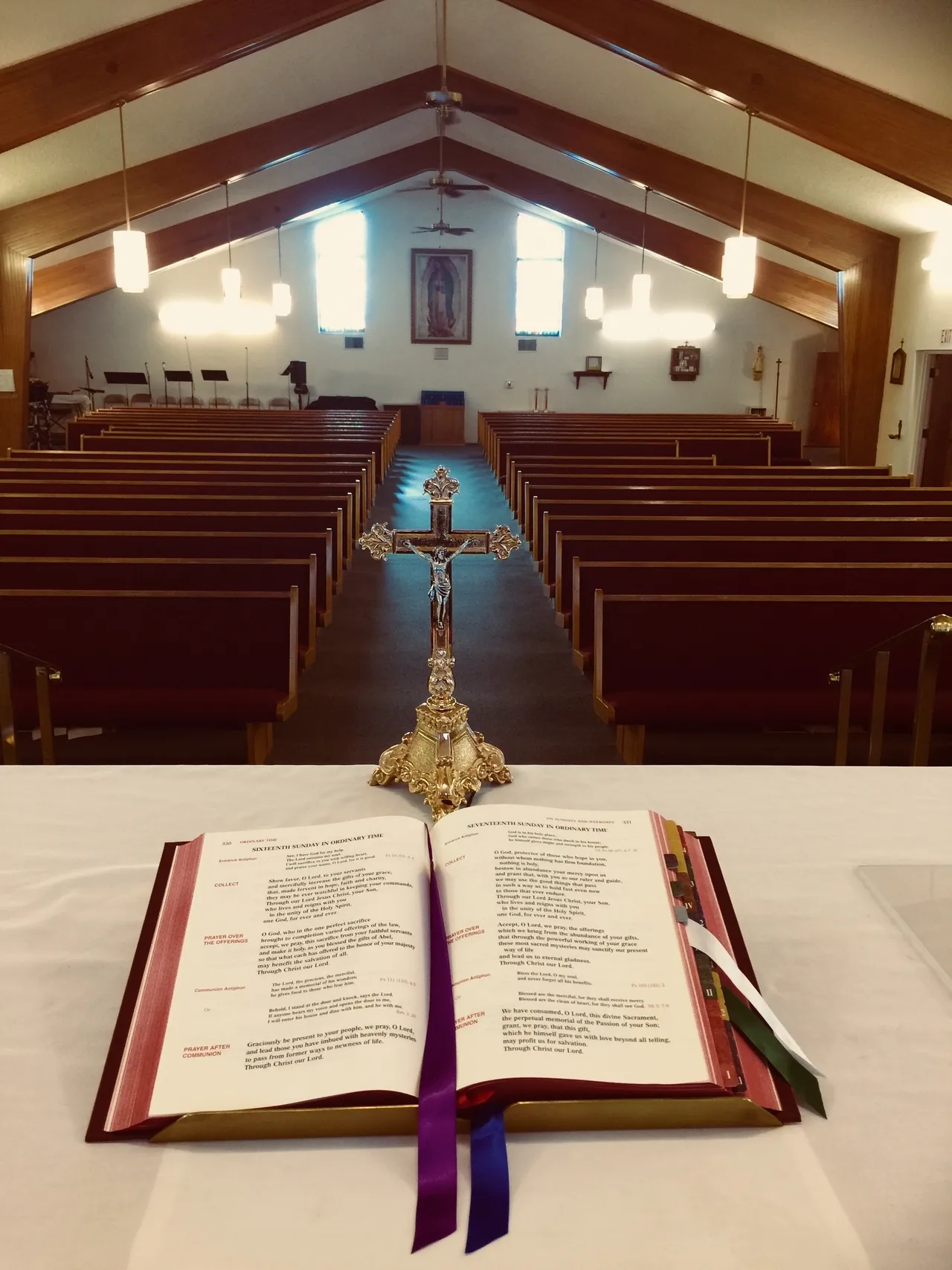 A church with pews and a cross in the background.