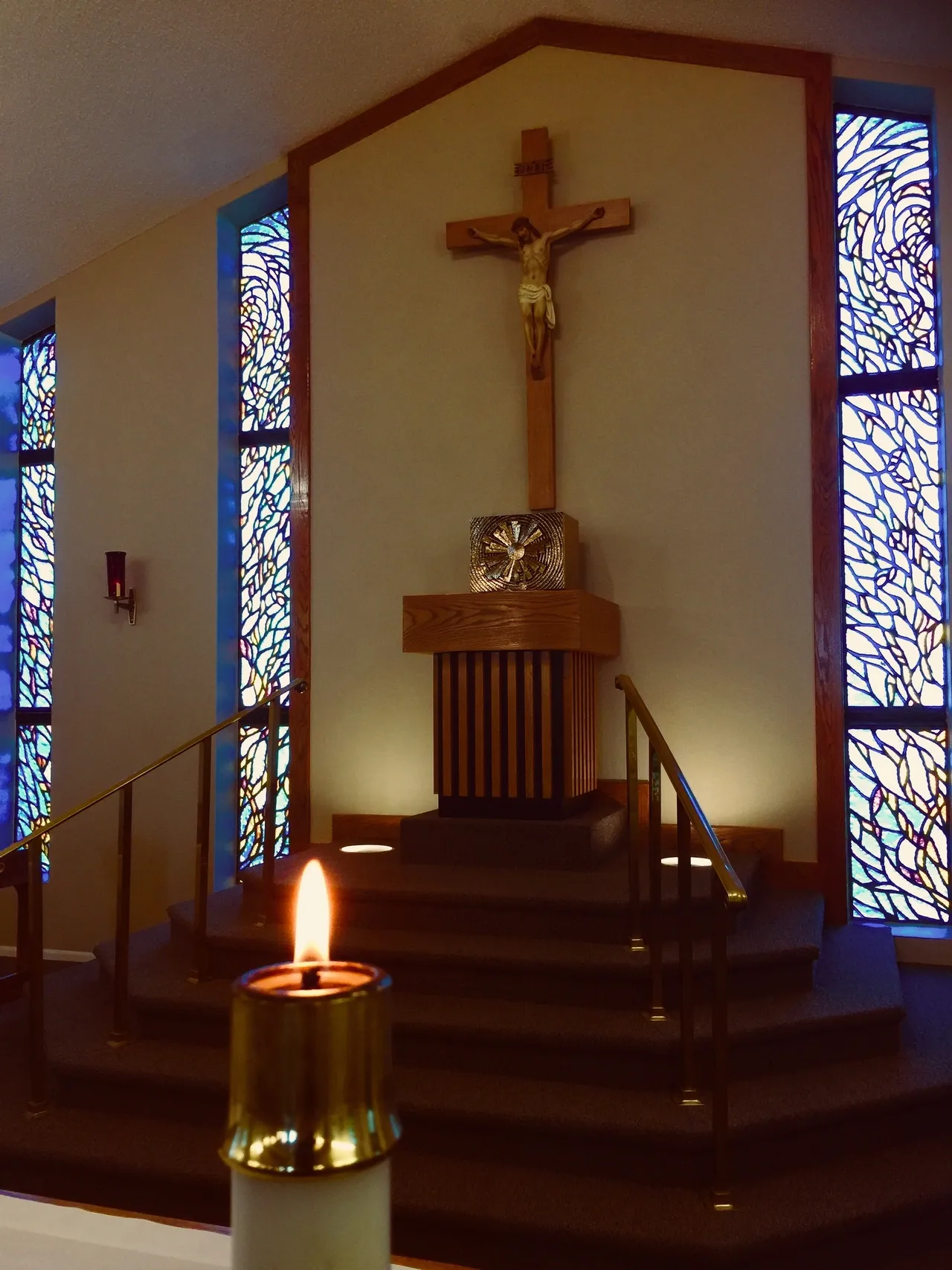 A candle is lit in front of the cross.