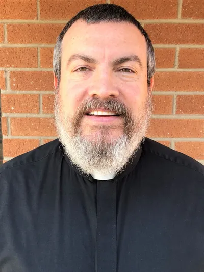 A man with a beard and mustache wearing a black shirt